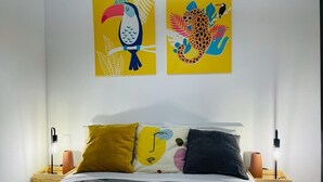 Ein Schlafzimmer mit einem Bett, zwei Nachttischen, einer Kommode und zwei Wandbildern.