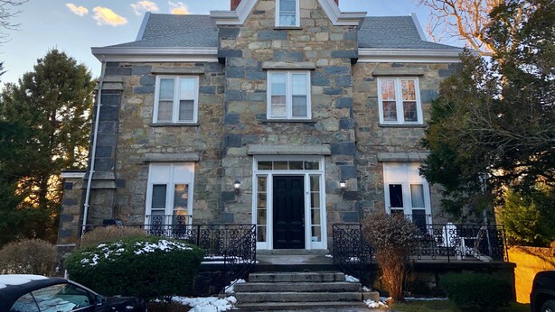 A stone building with a central entrance, two side wings, and a symmetrical design. - NEW! Historic Townhome - Live among the Mansions 3BR (Newport)