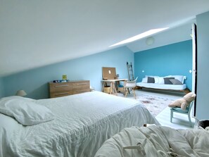 A bedroom with a bed, a desk, a chair, and a dresser.