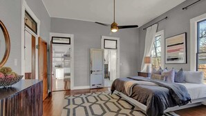 A bedroom with a bed, a ceiling fan, and a geometric rug. - Luxury Stay Right Off Central Main St - Hot Tub! (Fredericksburg)