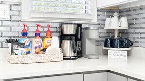 A kitchen counter with a coffee maker, coffee mugs, and coffee creamer bottles. - 2 for 1❗️2 separate houses (Pensacola)