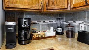 A kitchen with wooden cabinets, a Keurig coffee maker, a blender, and a toaster. - Eternity's Edge -Hike/Stargaze, Peaceful, Polished (Twentynine Palms)