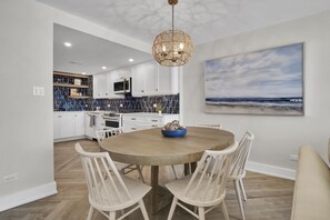 Enjoy meals in this kitchen with a central island, sink, and microwave, offering a view of the ocean.