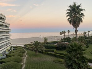 A hotel with a view of the beach, palm trees, and a well-maintained garden. - T2 CABIN with a terrace and exceptional ocean views (Canet-en-Roussillon)