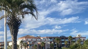 A hotel with a red roof, multiple balconies, and a sign reading "FLAMANTS ROSES". - T2 CABIN with terrace and exceptional sea view (Canet-en-Roussillon)