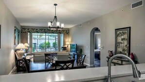 A modern kitchen with a dining area, a chandelier, and a view of the outdoors. - Beautiful Resort in Quiet, Gated Community w Pool (Port Charlotte)