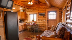 A log cabin interior with a kitchen, dining area, and living room. - The Ranch House Cabin at J&J Cabins (Salmon)