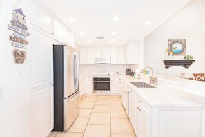 Fully equipped kitchen with refrigerator, oven, microwave, and sink.