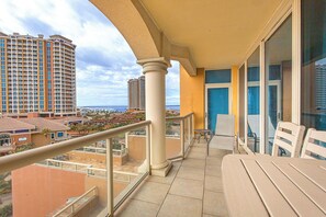 Enjoy the stunning city view from this balcony with a seating area and glass door leading to the interior.