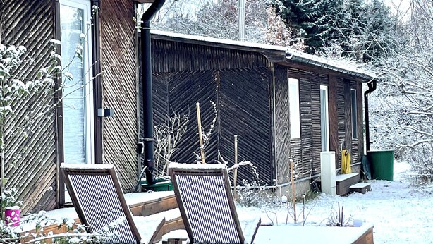 Una baita di legno con veranda e due sedie.