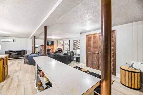 Relax in a spacious living area with a long countertop, high ceiling, and cozy fireplace.