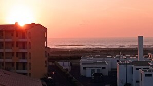 Un ensemble de bâtiments situé sur la côte, offrant une vue sur la mer au coucher du soleil.