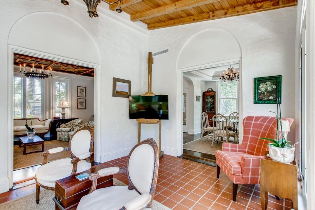 A spacious living room with a fireplace, a television, and a dining area with chairs.