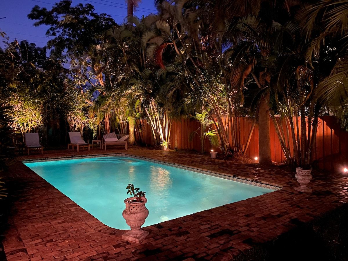 Ein rechteckiger Pool mit einer gefliesten Umrandung, umgeben von einer Ziegelterrasse.