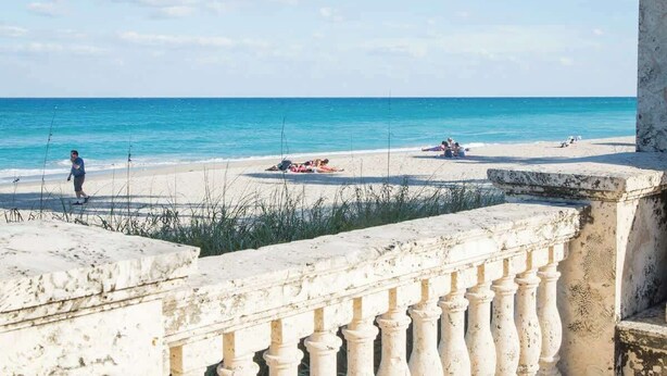 A beach with a stone balustrade and a clear view of the ocean. - Key Lime Cottage - Bask Poolside in a Historic Flamingo Park Gem (West Palm Beach)