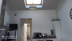 Una cocina compacta con tragaluces, un refrigerador, un microondas y un tostador.