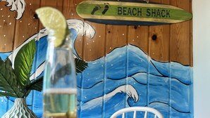 A wooden wall with a painted wave design and a sign that reads "BEACH SHACK".