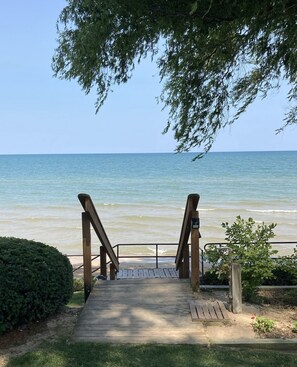 Un sendero de madera que lleva a una playa, con vista despejada al océano.
