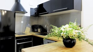 Eine moderne Küche mit schwarzen Geräten, einer Holzarbeitsplatte und einer Blumenvase.