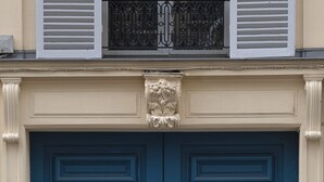 Eine Doppeltür mit einem dekorativen Wappen darüber.