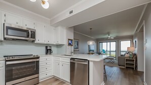 A modern kitchen with white cabinetry, stainless steel appliances, and a dishwasher. - Beautifully updated oceanfront condo with a pool (Atlantic Beach)