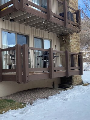 A building with a wooden balcony, windows, and a stone base. - Just Steps to ski slope (Snowmass Village)