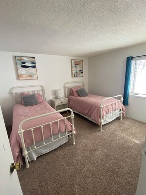 A bedroom with two beds, a nightstand, a lamp, and two abstract wall art pieces. - Just Steps to ski slope (Snowmass Village)