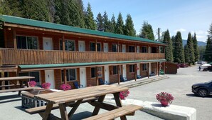 A two-story lodge with numbered rooms, outdoor seating, and a parking area. - Kitimat Lodge (Kitimat)