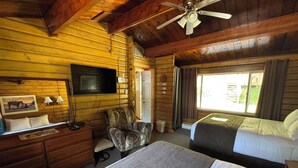 A wooden cabin-style room with two beds, a TV, a desk, and a chair. - Kitimat Lodge (Kitimat)