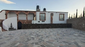 A modern building with a stone facade, a spiral staircase, and a courtyard with stone flooring. - Hotel Beraka (Ezequiel Montes)