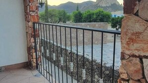 A stone archway leading to a balcony with a metal railing, overlooking a river and mountains. - Hotel Beraka (Ezequiel Montes)