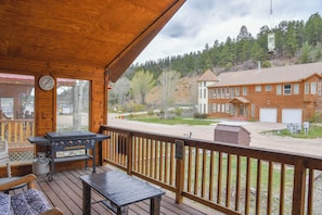 Une terrasse en bois avec un barbecue, une table et un banc.