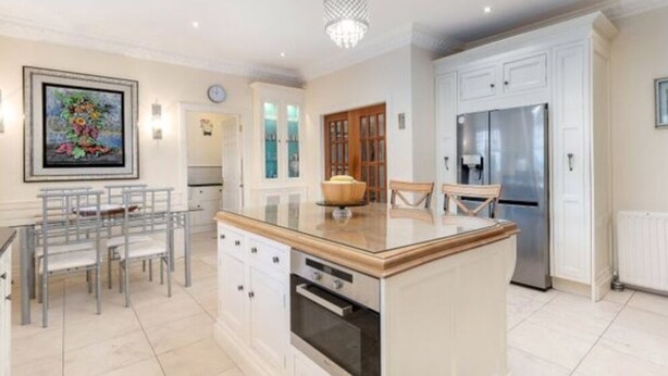 A modern kitchen with white cabinetry, a central island, and stainless steel appliances.