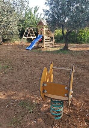 A playground with a slide and a wooden playhouse. - Villa (Oppède)