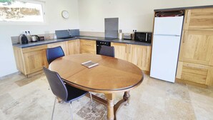 Una cocina moderna con una mesa de comedor de madera, sillas y un refrigerador.