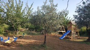 Un parque infantil con tobogán y columpios.