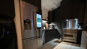 A modern kitchen with stainless steel appliances, a built-in oven, and a refrigerator with a digital interface. - Lake Superior premium bespoke accommodations with ultimate view! (Calumet Township)