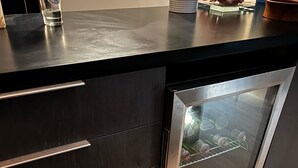 A kitchen with a black countertop, stainless steel appliances, and wooden drawers. - Lake Superior premium bespoke accommodations with ultimate view! (Calumet Township)
