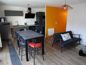 Cozy living space with a dining area, comfortable sofa, and modern kitchen.