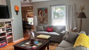 Una sala de estar con sofá, mesa de centro y televisor.