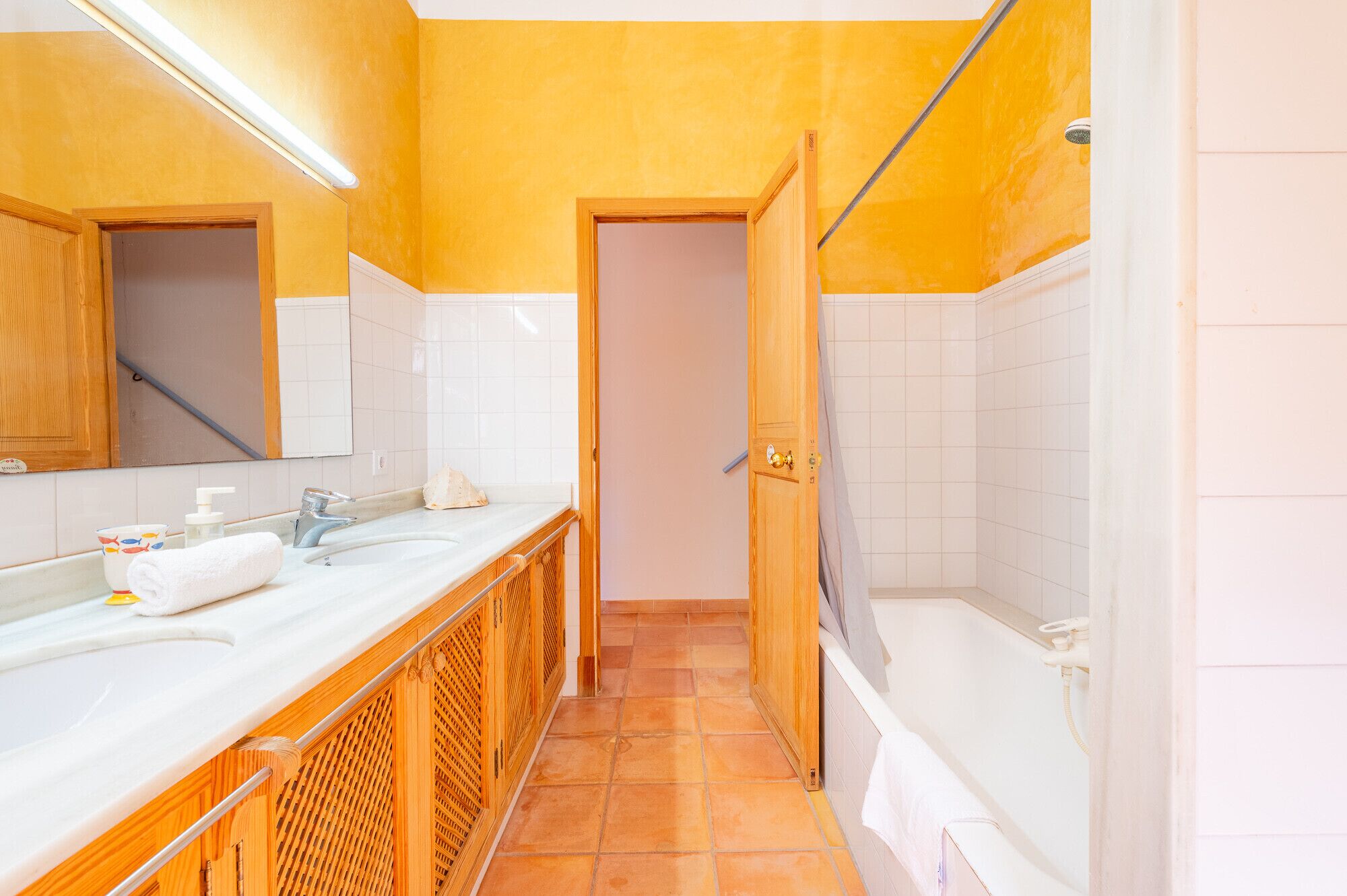 Un bagno con un mobile lavabo in legno, una vasca e una doccia.