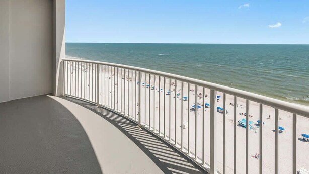 Een balkon met uitzicht op een strand en de oceaan.