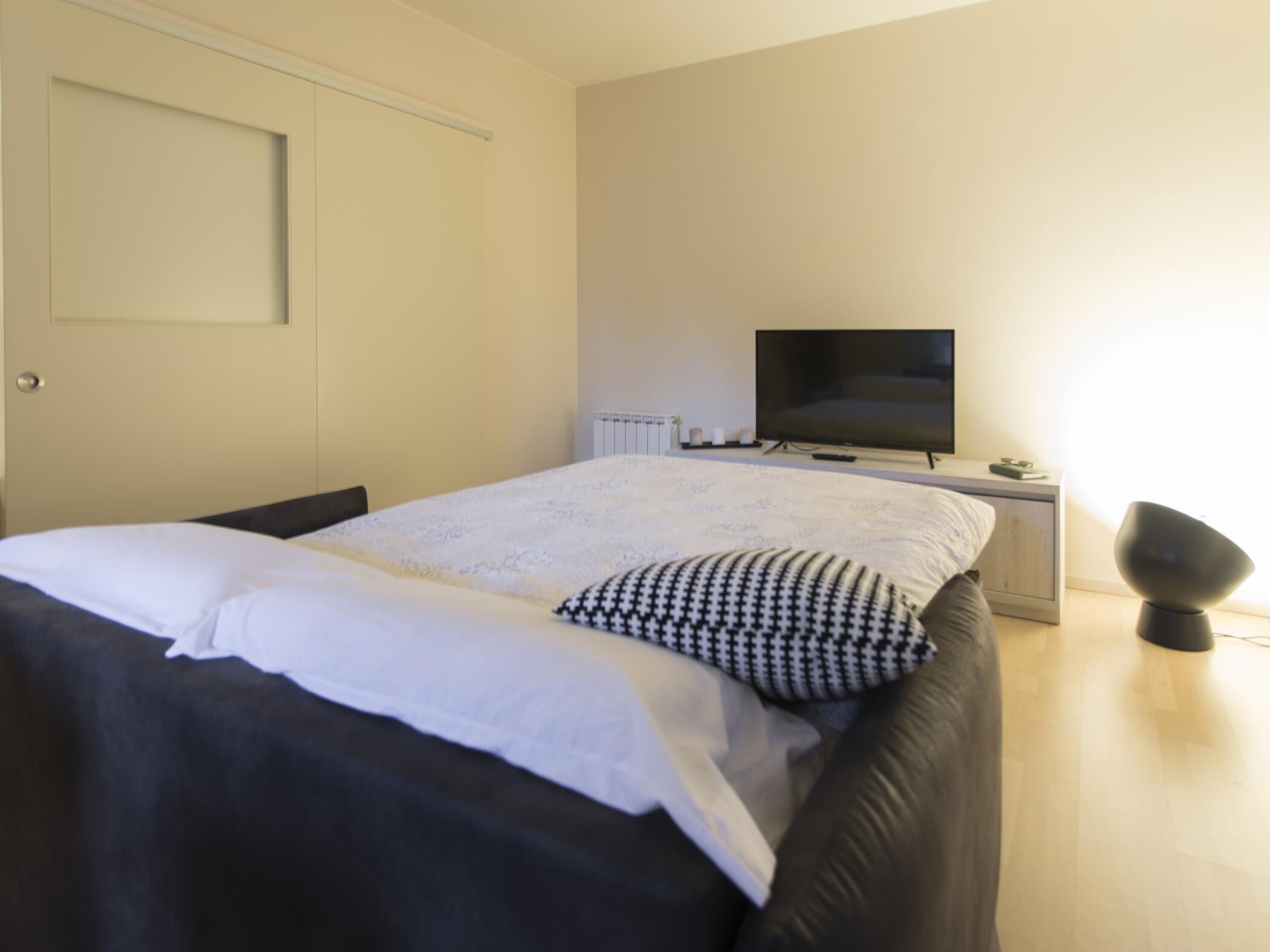 Una camera da letto con un letto, una televisione e un comodino.