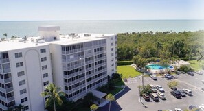 A multi-story hotel with a rooftop pool and a view of the ocean.