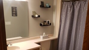 A bathroom with a vanity, toilet, and shower curtain. - EAA Spacious home w/ Pool  / Sleeps 10 (Winneconne)