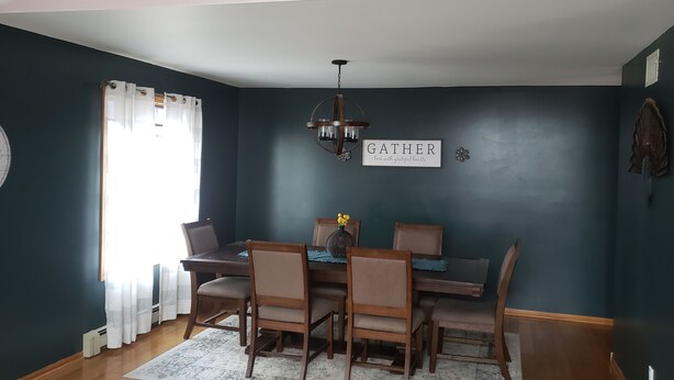 A dining room with a dark blue wall, a chandelier, and a sign that says "GATHER here with grateful hearts". - EAA Spacious home w/ Pool  / Sleeps 10 (Winneconne)