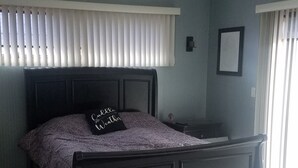 A bedroom with a bed, a ceiling fan, a bedside table, and a nightstand. - EAA Spacious home w/ Pool  / Sleeps 10 (Winneconne)