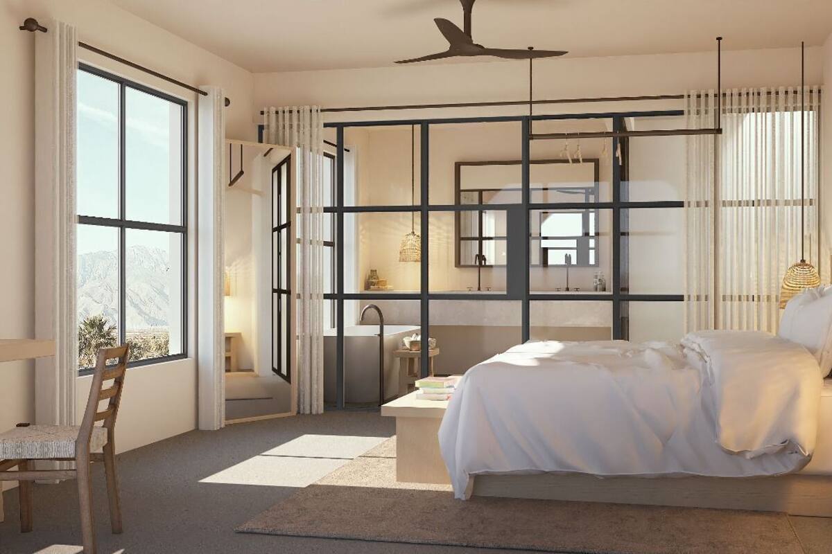 A bedroom with a bed, a desk, and a chair. There is a window with curtains and a view of mountains.