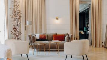 A modern living room with a sofa, two armchairs, a coffee table, and a floor lamp.