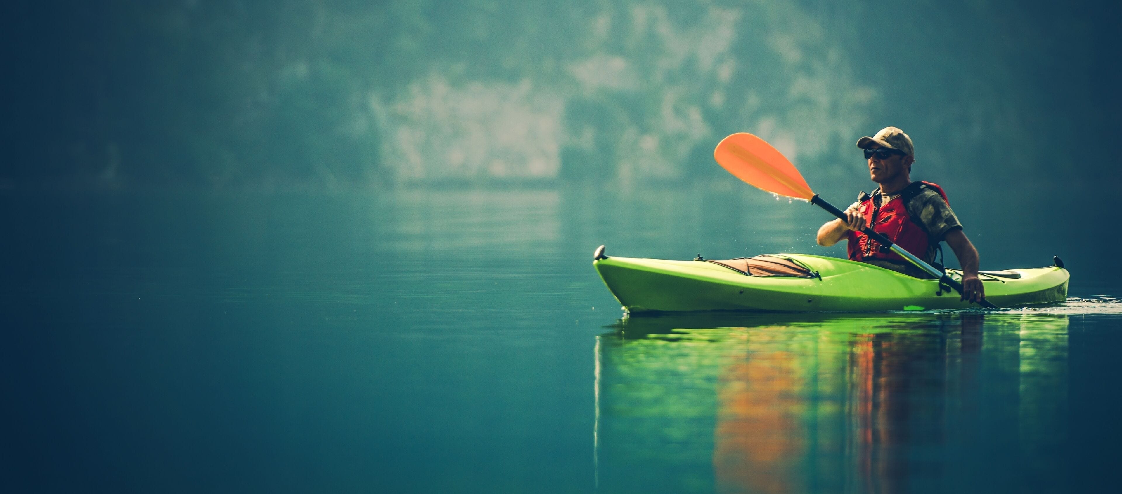 A person kayaking on calm water.